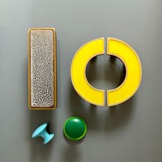 an assortment of objects are displayed on a gray surface, including a yellow object and a green object