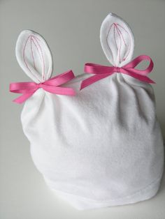 a white bag with pink ribbon and ears on it