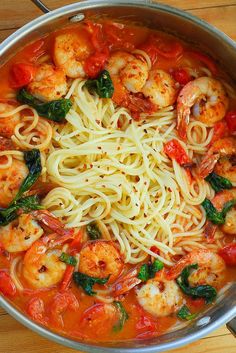 pasta with shrimp, spinach and tomato sauce in a pan