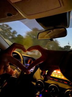 someone making a heart with their hands while driving