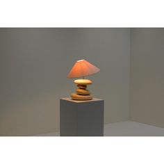 a lamp that is sitting on top of a block in the middle of a room