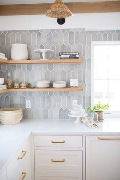 a kitchen with white cabinets and shelves filled with dishes