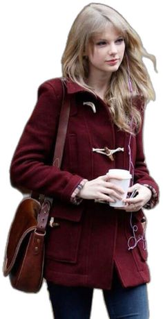 a woman in a red coat is holding a cup