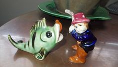 two ceramic fish figurines sitting on top of a table next to each other