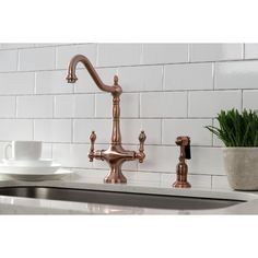 a kitchen sink with two faucets on the side and a white plate next to it