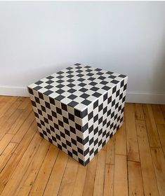 a black and white checkered box sitting on top of a wooden floor