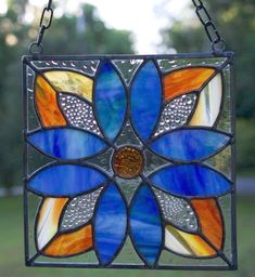 a stained glass sun catcher hanging from a chain