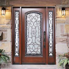 a wooden door with wrought iron designs on the sides and sidelights above it is surrounded by potted plants