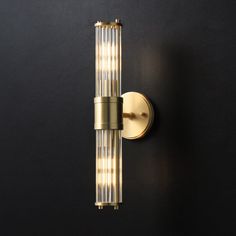 a wall mounted light on the side of a black wall with gold trimmings