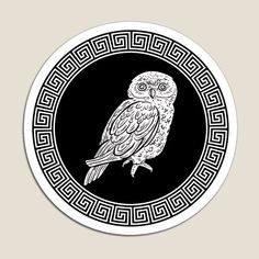 an owl sitting on top of a black and white circle with greek meanos around it