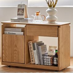 a small wooden table with books and magazines on the bottom shelf next to a vase filled with flowers