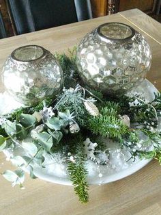 three glass containers filled with plants on top of a wooden table next to each other