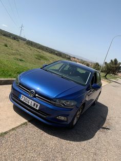 a blue car parked on the side of a road