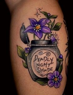 a woman's thigh with flowers and a jar that says deadly night shade on it