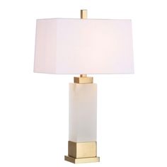 a table lamp with a white shade on the base and a gold frame around it