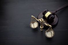 a judge's gaven and scale sitting on top of a wooden table next to each other