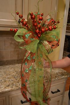 a young boy standing in front of a kitchen counter with a bow on it's head