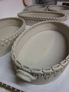 three white dishes sitting on top of a table