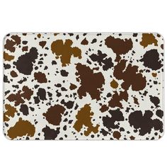 a brown and white animal print rug with spots on it's surface, in the shape of a cow pattern