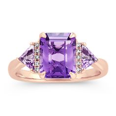 One emerald cut amethyst gemstone (approx. 2.14 carats) highlights this exquisite ring. Two trillion amethyst gemstones (approx. .35 carat TW)  and 10 round diamonds (approx. .05 carat TW) make brilliant accents. Crafted from quality 14 karat rose gold  this bold ring measures 2mm at the band and has a total gem weight of approximately 2.54 carats. Mafia Princess, Michael Hill, Amethyst And Diamond Ring, Princess Luna, Bold Rings, Natural Diamond Ring, Platinum Jewelry, Stylish Rings, Amethyst Necklace