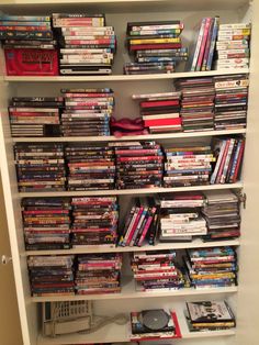 a bookshelf filled with lots of different types of movies and dvds on it