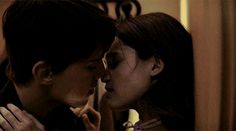 two people are kissing each other in front of a mirror with their faces close together