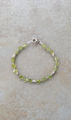 "Gift for August birthday, birthday bracelet for teens, one of a kind bracelet Sterling Silver and genuine peridot handmade beaded bracelet 7\".  All 2mm round and laser cut oval beads  are sterling silver. Peridot are oval faceted beads and vary in size from 4mm - 5mm.  Peridot, the bright green color of nature, is associated with harmony, good health, restful sleep, and peacefulness. Known as the stone of compassion, peridot calms anger by giving renewal to all things. When set in gold, this g Green Round Birthstone Bracelet, Green Sterling Silver Beaded Bracelets, Spiritual Green Beaded Sterling Silver Bracelets, Handmade Green Bracelets For Birthday, May Birthstone Faceted Beads Bracelet, Adjustable Peridot Bracelets For Gifts, Green Faceted Spiritual Bracelets, Green Sterling Silver Bracelets With Round Beads, Green Beaded Sterling Silver Bracelet