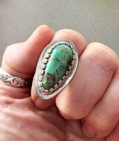 When I first purchased this stone I had every intention of keeping it for myself as I've never seen chrysophrase with these colors.  Pale mint green, gold and even purple matrix.  I set it in castellated sterling silver bezel and then on a heavy sterling silver back plate.  The shank looks like 3 strands of sterling silver put together.  The ring itself measures 1 1/4 inches in length which is a tear drop shape and is a size 8 3/4 - 9 US. For more artisan jewelry you can enter my shop here:  htt Handmade Turquoise Opal Ring Artisan Style, Handmade Artisan Turquoise Opal Ring, Handmade Turquoise Artisan Opal Ring, Handmade Southwestern Opal Ring, Artisan Turquoise Chrysoprase Rings, Handmade Turquoise Opal Ring With Unique Style, Bohemian Chrysoprase Turquoise Ring, Artisan Green Chrysocolla Rings, Bohemian Turquoise Chrysoprase Ring