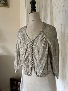 Gorgeous vintage 1930s 1940s metallic blouse. Silver (with subtle golden shimmer depending on the light) lamé floral print fabric. Sweetheart neckline, 13 fabric-covered buttons down the front, 1 hook-and-eye closure at bottom front center, batwing sleeves, three-quarter length sleeves with beautiful tulip shape detail at cuffs.   Such a cool statement blouse! Perfect for your next night out on the town or party! And of course for the Holiday Season and New Year's Eve !   Very versatile: looks v Vintage Party Blouse With Buttons, Statement Blouse, Metallic Blouses, Womens Blouses, Floral Print Fabric, Antique Clothing, If You Want Something, Fabric Covered Button, Batwing Sleeve