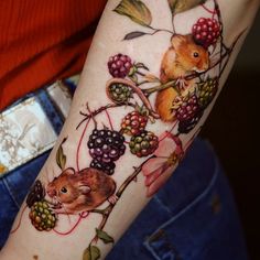 a hamster and berries tattoo on the arm