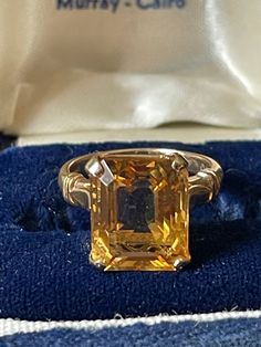 14K Citrine ring from the Art Deco era.  This is in a beautifully crafted mounting signed TPO and hallmarked 14K. In the center prong set is a 6.00 carat natural citrine gemstone.  Finger size 4. This can be sized up to 3 sizes for a minimal charge.  Otherwise this is truly an Art Deco pinky ring.  Circa 1930. Formal Orange Topaz Ring With Center Stone, Formal Hallmarked Emerald Cut Sapphire Ring, Classic Topaz Birthstone Ring, Classic Emerald Cut Topaz Ring For Formal Occasions, Classic Orange Topaz Ring For Anniversary, Classic Yellow Gold Topaz Ring, Citrine Engagement Ring Vintage, Formal Emerald Cut Solitaire Topaz Ring, Formal Topaz Ring With Prong Setting