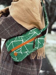 a woman carrying a green and orange bag in the snow