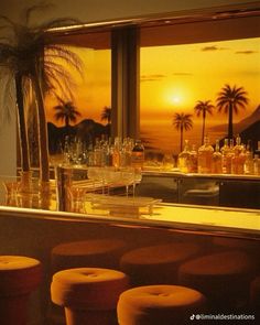 a bar with stools in front of a window and palm trees on the other side