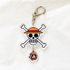 a skull and crossbone keychain with a pirate hat on it's head