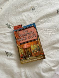 the pumpkin spice cafe book is laying on a bed