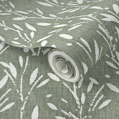 a green and white floral wallpaper with leaves on the side, it has a roll of