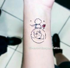 a small tattoo on the wrist of a person with a cat and flower in it