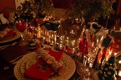 a dining room table is set with christmas decorations and candles for the centerpieces