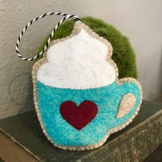 a tea cup with a heart on it is sitting on top of a bookcase