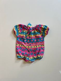 An excellent condition, one tiny pin dot near leg opening, abby bubble romper. One piece romper in 100% cotton, 90s style in pink, teal, yellow with floral and squiggle print. Snap crotch closure, tie neck, cap sleeves. Tagged 12 months, seems accurate. Measures 16 inches long shoulder to saddle, and 12.5 inches across pit to pit. Fitted Multicolor Cotton Bodysuit, Multicolor Short Sleeve Cotton Bodysuit, Multicolor Cotton Short Sleeve Bodysuit, Multicolor Cotton Playtime Bodysuit, Printed Fitted Onesie For Playtime, Fitted Printed Onesie For Playtime, Multicolor Cotton Bodysuit For Playtime, Playful Multicolor Short Sleeve Onesie, Multicolor Spring Bodysuit For Playwear