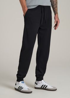 Relax In Style The Ultimate Extra-Long Men's Joggers Ready to meet your new favorite joggers? Our Wearever 2.0 Fleece Tall Men's Joggers are here to revolutionize your chill time. Designed for men over 6', these aren't just any joggers—they're your go-to for year-round comfort. Made from cozy fleece with a stretch fabric that moves with you, they offer a modern fit that's just right, not too tight. The updated trim, stylish drawstring, and thoughtful branding elevate these from basic to essentia Black Tapered Leg Activewear For Jogging, Black Joggers With Comfort Waistband And Tapered Leg, Black Tapered Leg Joggers With Comfort Waistband, Black Joggers With Ribbed Waistband And Tapered Leg, Black Tapered Joggers With Ribbed Waistband, Black Tapered Leg Joggers With Ribbed Waistband, Black Tapered Leg Joggers Athleisure, Black Tapered Leg Joggers For Athleisure, Black Tapered Leg Sweatpants For Gym