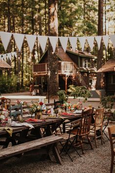 an outdoor table set up for a party with bunting and flags in the background