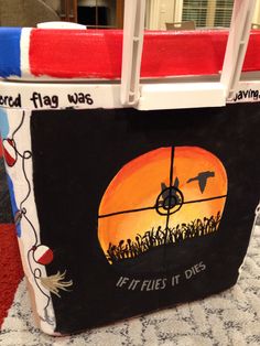 a cooler bag painted with an image of a bird and target in the sky on it