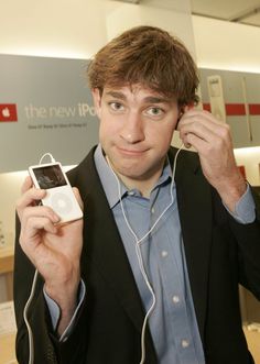 a man in a suit holding up an ipod