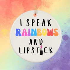 i speak rainbows and lipstick ornament hanging from a string on a colorful background