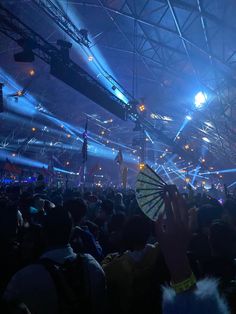 a crowd at a concert with lights and fans