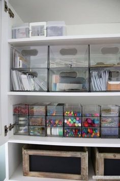 the shelves are filled with plastic bins and craft supplies