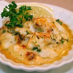 a white plate topped with food and garnished with parsley on top of it