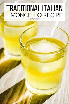 two glasses filled with lemonade sitting on top of a wooden table