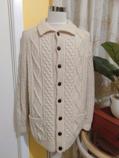 100% Pure Wool Cable Knit Sweater made in The Republic of Ireland. It's Ultra Thick and Warm and in great shape. Would Suit Men's Large Measurements: Collar 26" Across Shoulders 20" Chest 54" Hips 48" Sleeves 26" Long Wrists 10" Two Front Pockets 6" x 6" Length 32" 8 Buttons x .75" Diameter Sweater has a 2" Give (Stretch) Classic Cable Knit Polo Sweater, Classic Crew Neck Sweater With Button Closure, Classic White Sweater With Button Closure, Classic Knitted Cardigan, Classic Cream Outerwear With Crew Neck, Brand Clothes, Fisherman Sweater, Republic Of Ireland, Sweater Making